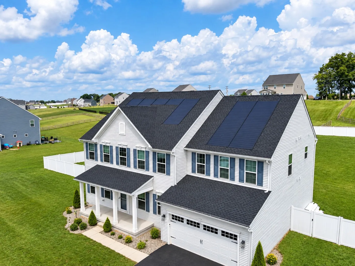 Finished home with dark roofing, white siding and rooftop solar