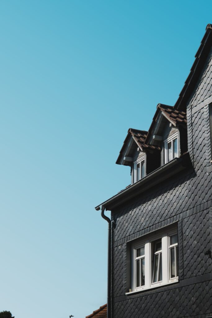 Dormer with white trim and window against a blue sky