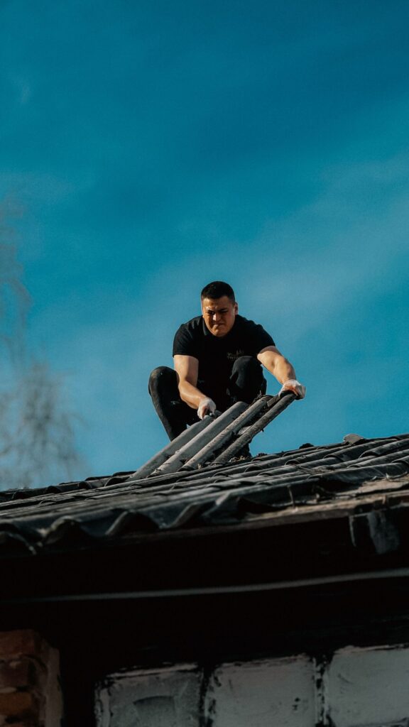 Roofer kneeling on a damaged roof